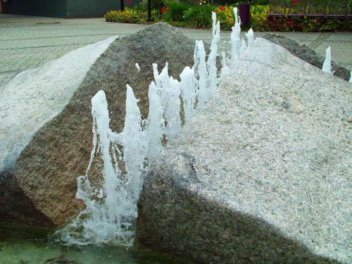 Platzbrunnen aus Naturstein mit fließendem Wasser